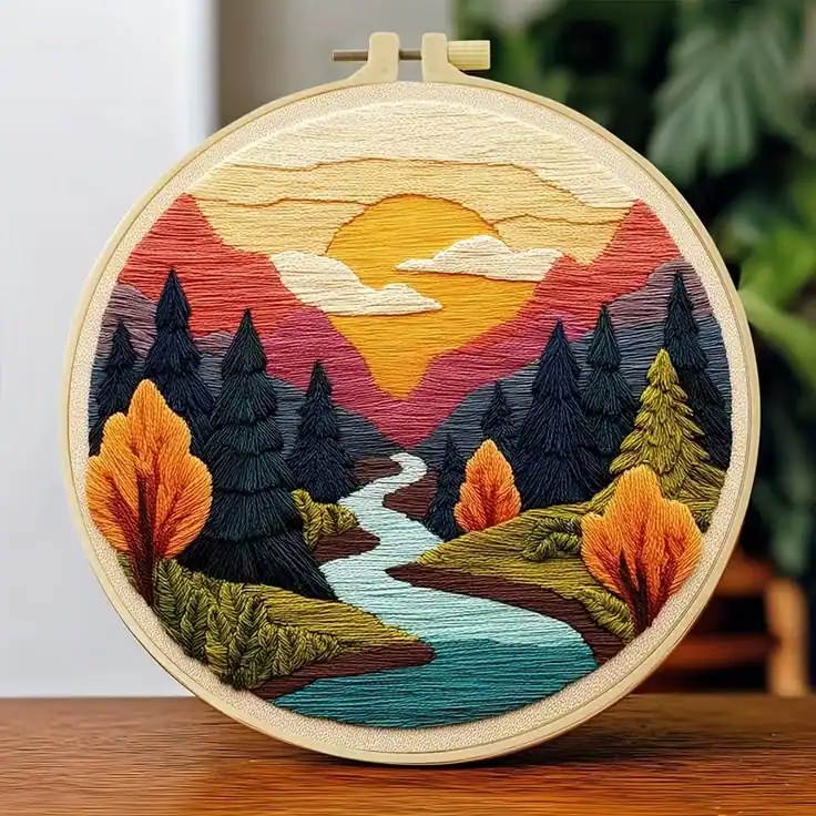Cuadro bordado de paisaje con montañas y río